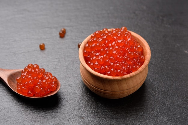 Caviar de salmón chum rojo granulado fresco en una cuchara de madera, comida deliciosa y saludable, cerrar