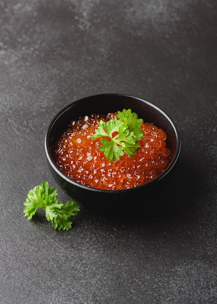 Caviar de salmón con perejil en un tazón Merienda de mariscos sobre fondo oscuro Delicadeza de lujo Vista lateral