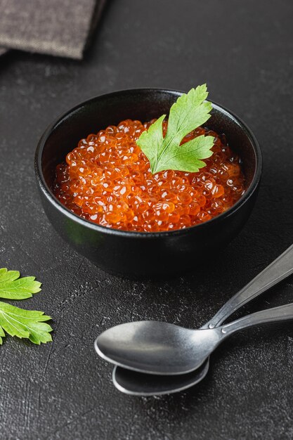 Foto caviar de salmón rojo con perejil en un cuenco