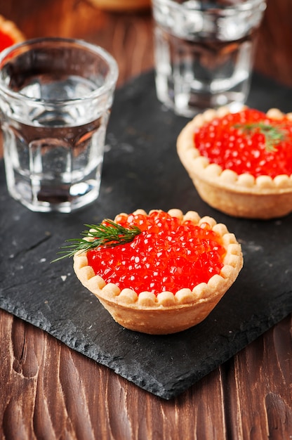 Caviar tradicional russo vermelho na mesa de madeira