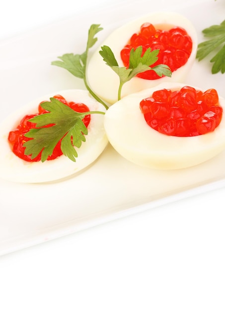 Caviar vermelho em ovos no prato branco isolado no branco
