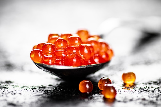 Caviar vermelho em uma colher em cima da mesa