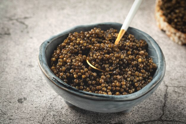 caviar vermelho em uma tigela sobre uma superfície de concreto cinza