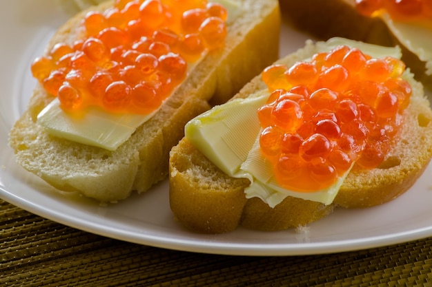 Caviar vermelho no pão com manteiga closeup muitos sanduíches