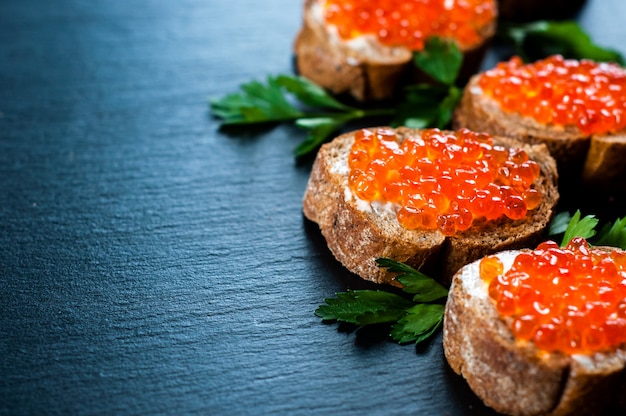 Foto caviar vermelho sobre fundo de ardósia