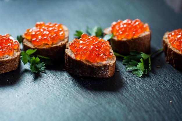 Foto caviar vermelho sobre fundo de ardósia