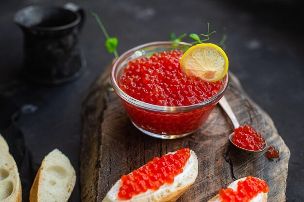 Caviar vermelho sobre fundo escuro Sanduíches com caviar