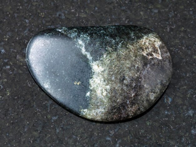 Cayó piedra Olivenita sobre fondo oscuro