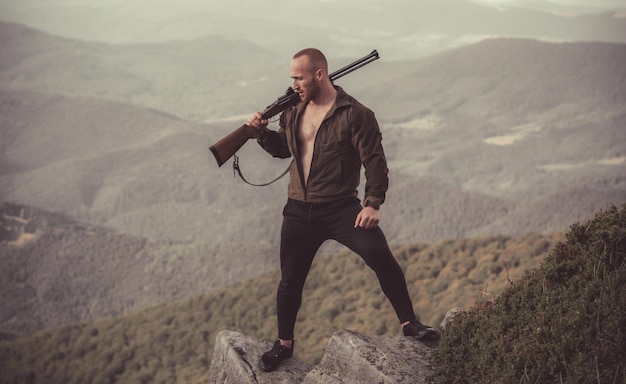 Un cazador con un arma de caza caza en el bosque de verano cazador de hombres con un arma de caza en rusia hunter tar