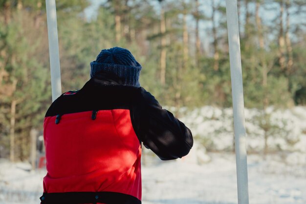 Cazador de camuflaje con rifle en bosque de invierno. Concepto de caza. Hombre asegurando una reserva, en un día de nieve. Hunter apunta con un arma en el bosque nevado