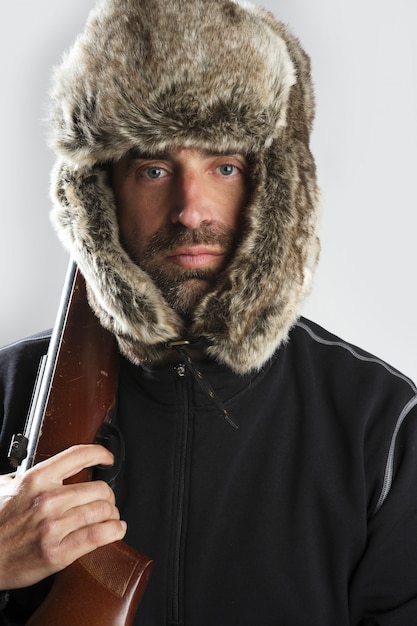 Foto cazador invierno piel sombrero hombre retrato sosteniendo pistola