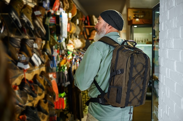 Cazador con mochila en el escaparate de la tienda de armas