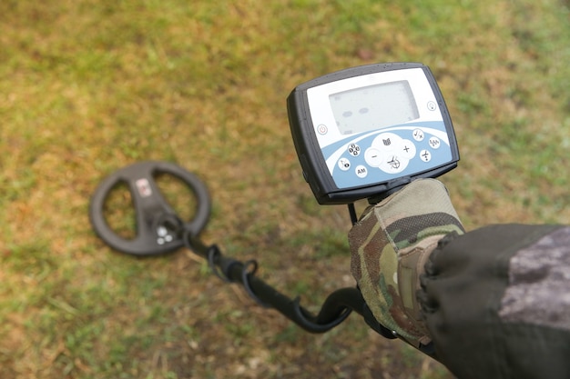 Cazador de tesoros con un detector de metales en el campo.