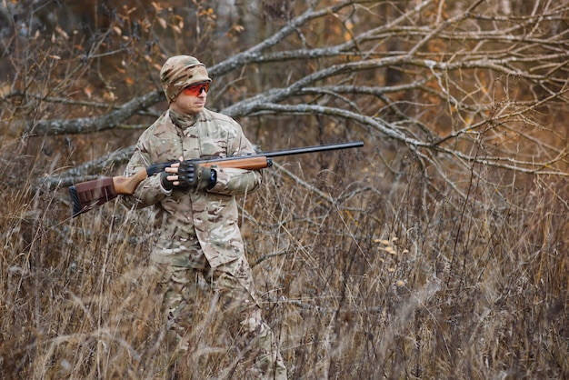 Cazador en uniforme con un rifle de caza