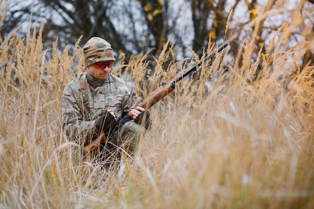 Cazador en uniforme con un rifle de caza