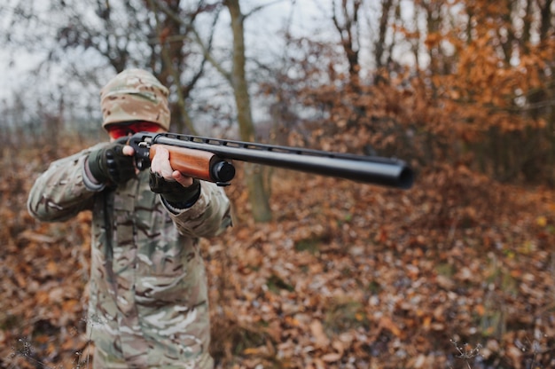 Cazador en uniforme con un rifle de caza