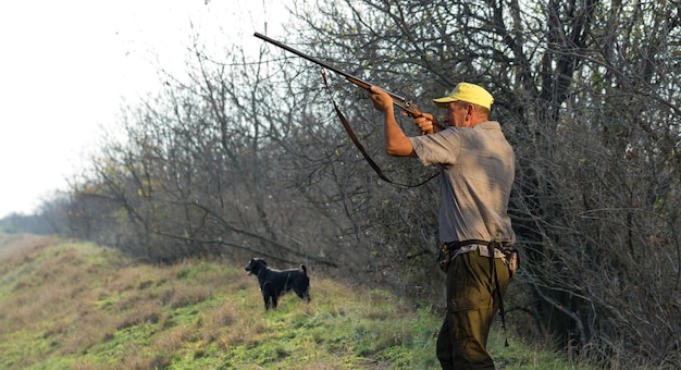 Foto cazadores con drathaar alemán y spaniel, caza de palomas con perros con chalecos reflectantes