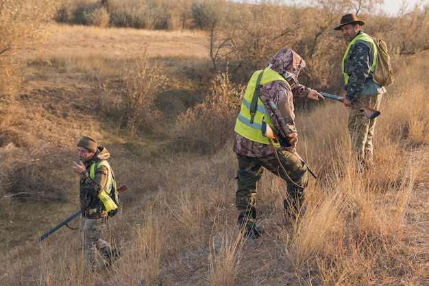 Cazadores con drathaar alemán y spaniel, caza de palomas con perros con chalecos reflectantes