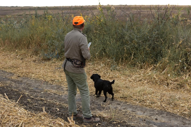 Cazadores con drathaar alemán y spaniel, caza de palomas con perros con chalecos reflectantes