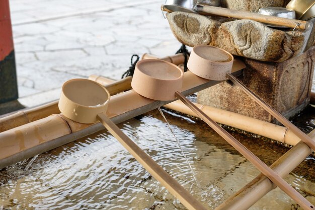 Cazo de bambú ordenado en el lavabo tradicional japonés en el templo