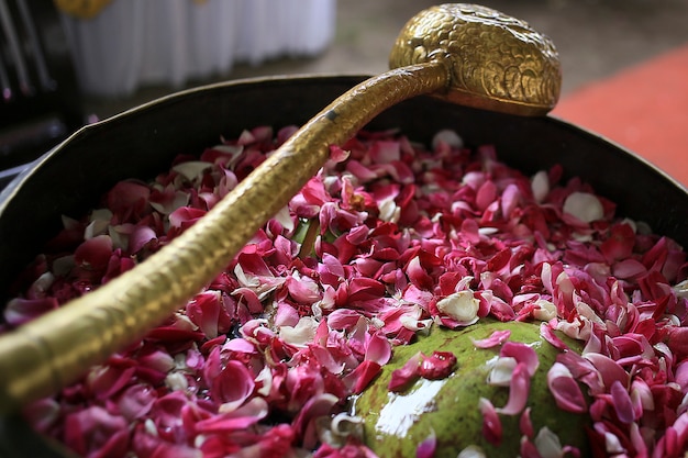 Foto un cazo dorado y un gran cuenco de cobre lleno de agua y lleno de flores en panggih