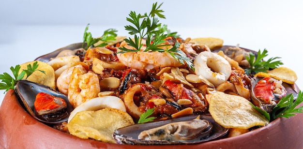 Cazuela de frutos do mar comida típica espanhola servida em panela de barro
