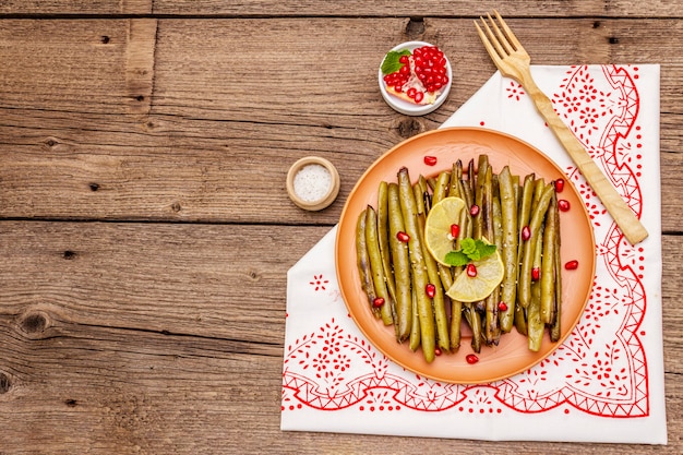 Cazuela de judías verdes al horno con semillas de sésamo, granada, menta y limón