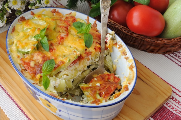 Cazuela de pasta con calabacín y tomate y queso en la mesa