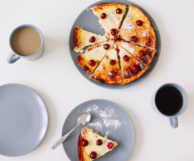 Cazuela de queso con bayas y una taza de café en la vista superior de la mesa