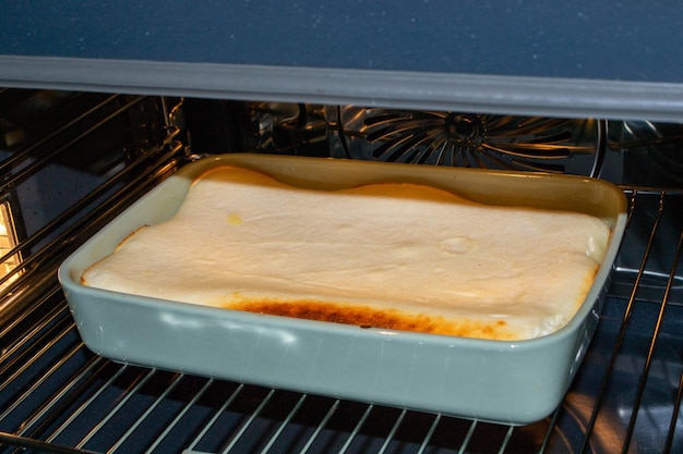 La cazuela de requesón con frambuesas y avellanas en forma de vidrio se hornea en el horno