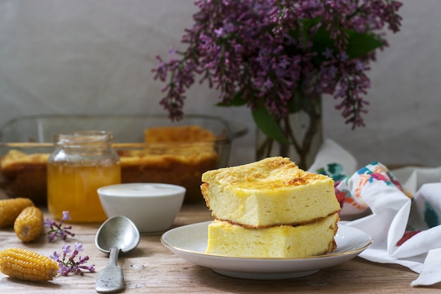 Cazuela de requesón tradicional rumana o moldava con harina de maíz, servida con miel y crema agria.