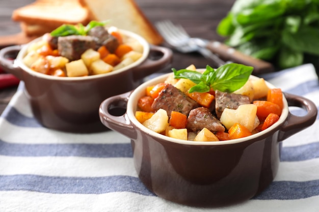 Cazuela con sabrosa carne y patatas en la mesa