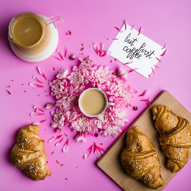 Foto ccoffee y croissant en un fondo rosado