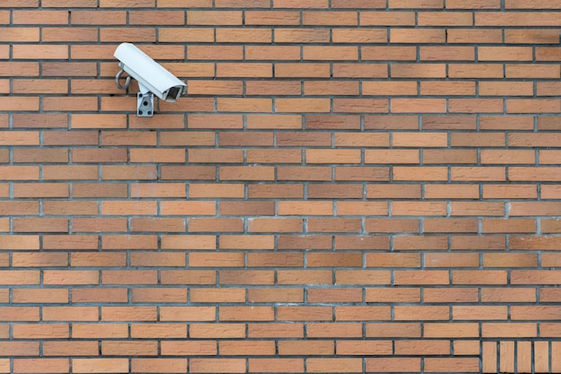 CCTV-Kameras sind an der Ziegelwand am Eingang zum Supermarkt installiert Sicherheits- und Diebstahlschutzsysteme Eine Überwachungskamera und ein gepanzertes Fenster in der Bank