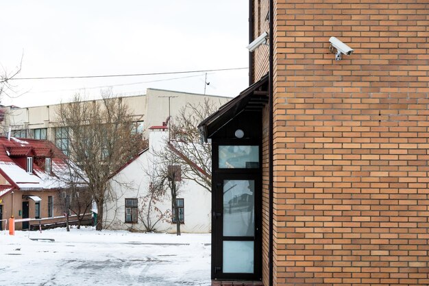 CCTV-Kameras sind an der Ziegelwand am Eingang zum Supermarkt installiert Sicherheits- und Diebstahlschutzsysteme Eine Überwachungskamera und ein gepanzertes Fenster in der Bank