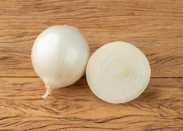 Cebola branca com metade sobre a mesa de madeira