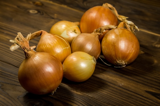 Cebola dourada crua na mesa de madeira