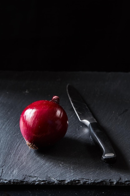 Cebola espanhola vermelha com faca de cozinha