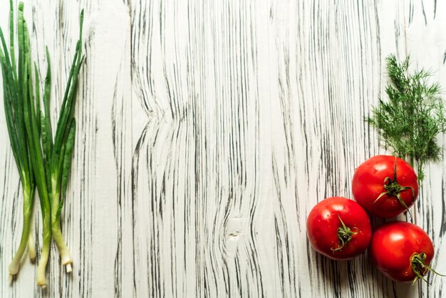 Cebola ovos de codorna tomate em uma mesa branca