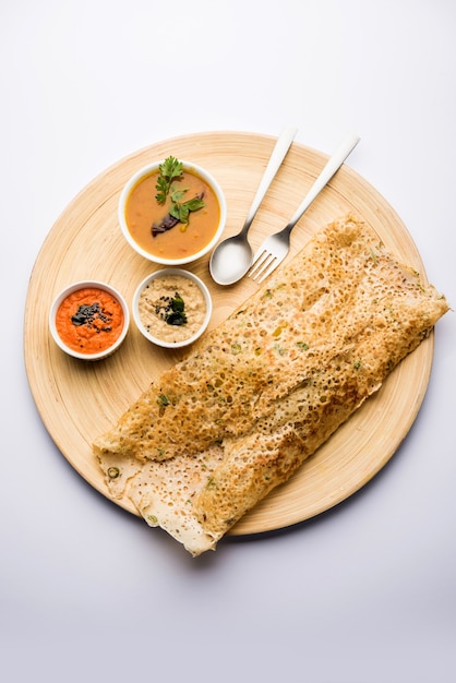 Cebola rava masala dosa é um café da manhã instantâneo do sul da Índia servido com chutney e sambar sobre um fundo melancólico. foco seletivo