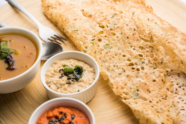 Cebola rava masala dosa é um café da manhã instantâneo do sul da Índia servido com chutney e sambar sobre um fundo melancólico. foco seletivo