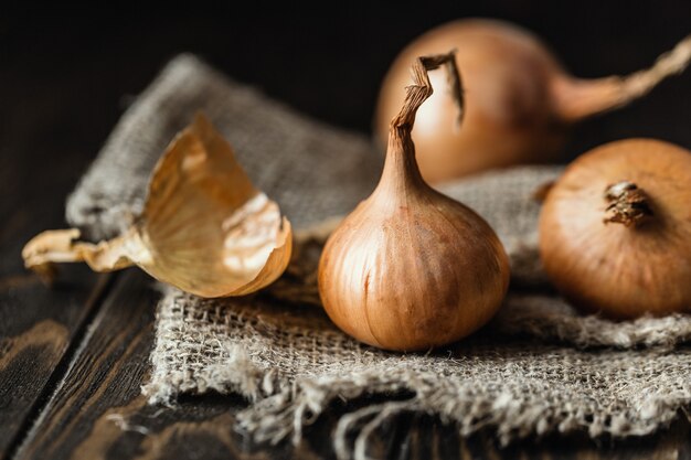 Cebolas frescas na mesa de madeira rústica.