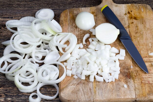 Cebolas maduras fatiadas em uma tábua, usadas para cozinhar alimentos e molhos