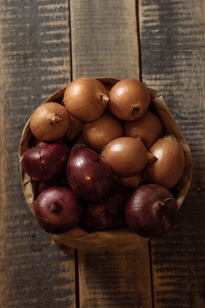 Cebolas na cesta a cebola é fundo de madeira de cebola branca