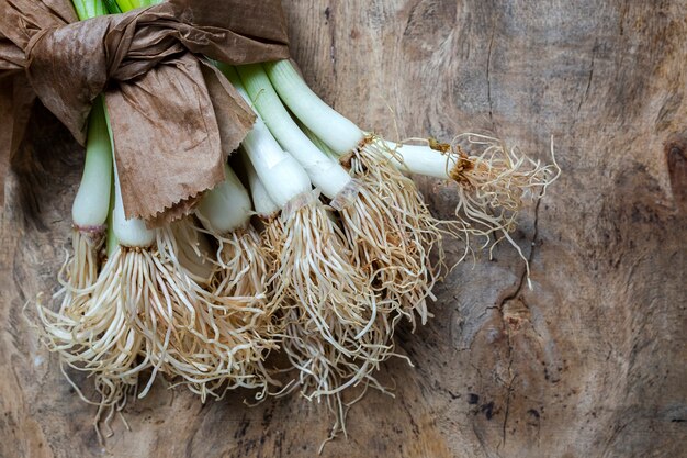 Cebolas vermelhas e brancas frescas na superfície de madeira