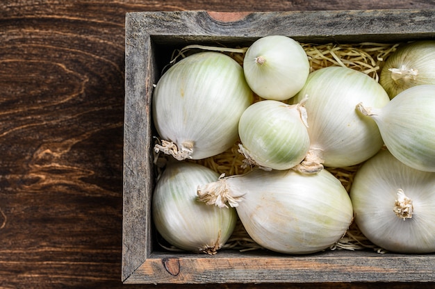 Cebolla blanca cruda en caja de madera