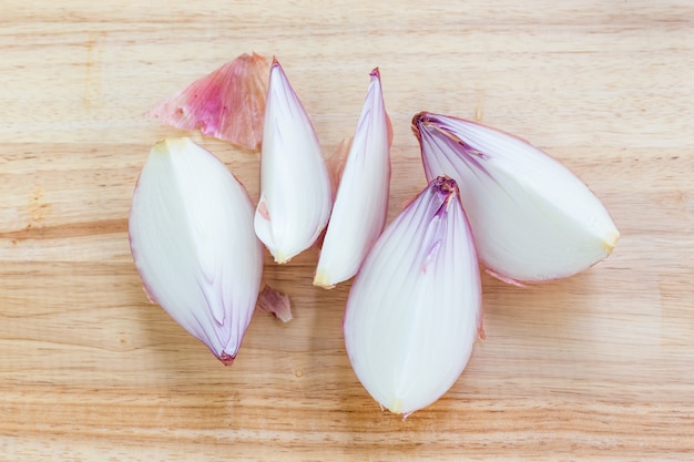 Cebolla grande y rodajas sobre tabla para cortar madera