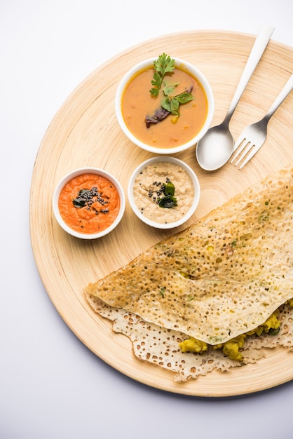 Cebolla rava masala dosa es un desayuno instantáneo del sur de la India que se sirve con salsa picante y sambar sobre un fondo de mal humor. enfoque selectivo