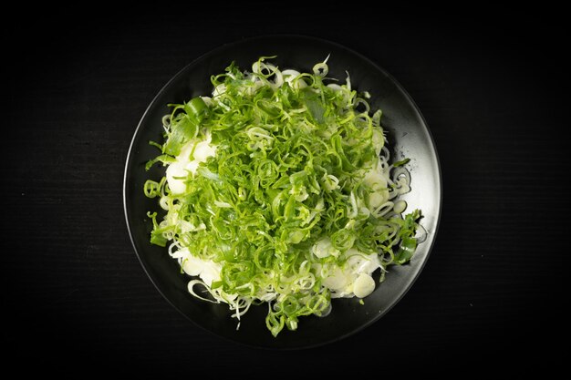 Cebolla verde picada fresca sobre fondo oscuro