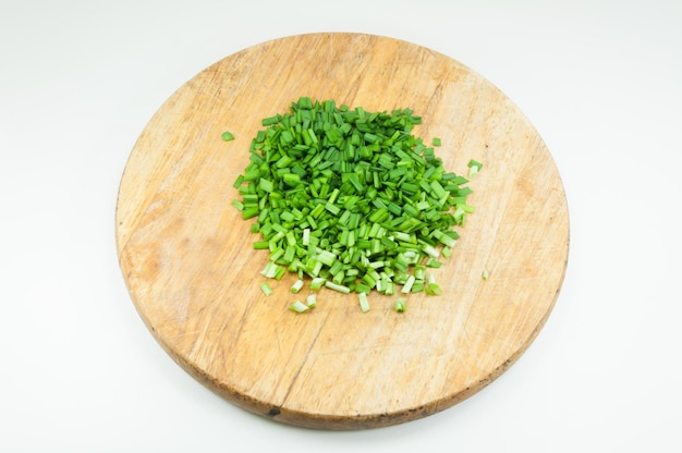 Una cebolla verde picada sobre una tabla de cortar de madera